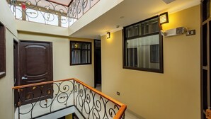 A multi-level interior with a staircase, a wooden door, and a window with a curtain. - Tikala Cusco Boutique Hotel (Cusco)
