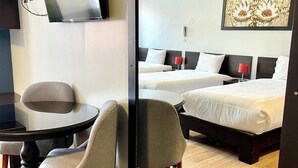 A hotel room with a large mirror reflecting a bed, two bedside tables, a TV mounted on the wall, and a desk with a chair. - Tikala Cusco Boutique Hotel (Cusco)