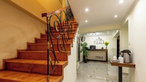 A staircase with ornate metal railings leading to a reception area with a sign reading "TIKALA". - Tikala Cusco Boutique Hotel (Cusco)