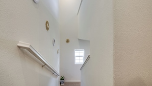 A narrow, white-walled stairwell with a small window at the top. - Spacious Family Home in Stockton - Pets Welcome! (Stockton)