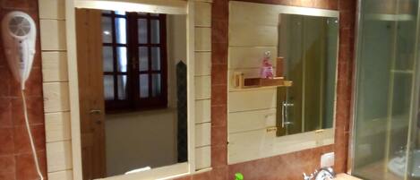 Un baño con dos lavabos, un espejo y un secador de pelo.