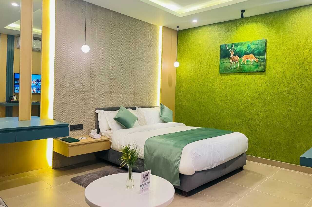 Ein modernes Hotelzimmer mit einem Bett, einem Nachttisch und einer Wand mit Grüner Struktur.