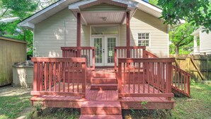 A two-story house with a front porch, a garage, and a fenced backyard. - Biloxi Home: Walk to Fishing & 2 Mi to Beach! (Biloxi)
