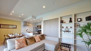 A modern living room with a sofa, coffee table, and a bookshelf. - Branchera naha akebono premist R65 (Naha)
