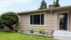 A single-story house with a front entrance, a small porch, and a well-maintained lawn. - Centrally located, newly renovated home (Federal Way)