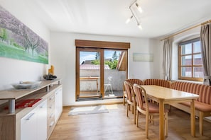 Et moderne køkken med træbordplade, et spiseområde med bænk og en skydedør til et udendørs område.