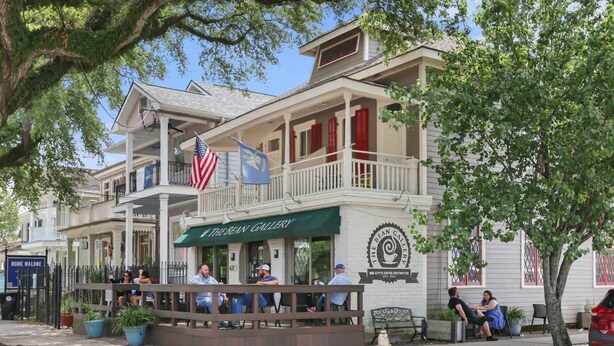 A two-story building with a green awning labeled "The Bean Gallery," a balcony with red shutters, and an American flag.