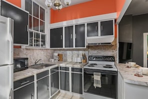 A kitchen with a stove, microwave, and cabinets.