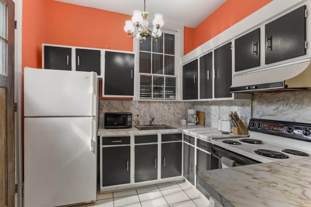 A kitchen with a refrigerator, microwave, stove, and cabinets.