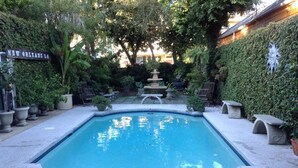 Una piscina rodeada de bancos de piedra y una fuente de piedra.