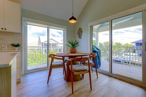A dining area with a round table, chairs, and a hanging light fixture. - Boater's Paradise | 170' Waterfront | 30' Dockage | Ramrod Key Retreat (Ramrod Key)