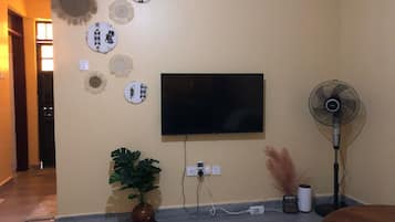 Appartement Deluxe, vue ville | Coin séjour | TV connectée de 24 pouces avec chaînes numériques