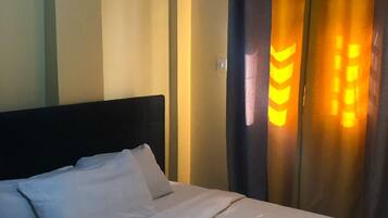 Relax in a cozy retreat with a neatly made bed, complete with crisp linens and plush pillows.