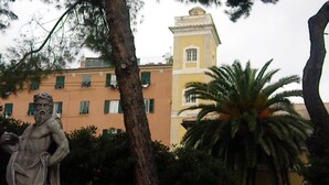 Una estatua en un jardín, con un edificio al fondo.
