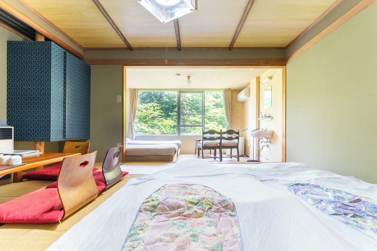 A room with a bed, a desk, a chair, a window, and a bathroom.