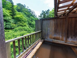 A wooden deck with a view of lush green forest. - Tabist Shiobaraonsen Kashiwaya Ryokan (Nasushiobara)