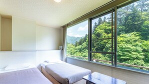 A hotel room with two beds, a small table, and a large window offering a view of a forested mountain landscape. - Tabist Shiobaraonsen Kashiwaya Ryokan (Nasushiobara)