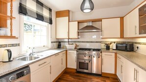 Een keuken met een wasmachine, een fornuis en een magnetron.