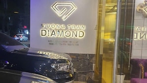 Entrada de un hotel con un cartel que dice "Vuong Tran Diamond Hotel" y un coche negro estacionado frente a él.