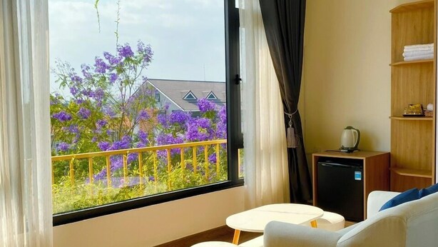Una habitación moderna con un ventanal grande, un sofá, una mesita y un armario.