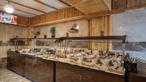 A buffet area with a marble wall, wooden ceiling, and potted plants. - Aysel Hanım Konağı (Gaziantep)