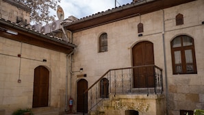 A building with a reception area, wooden doors, and a staircase with iron railings. - Aysel Hanım Konağı (Gaziantep)