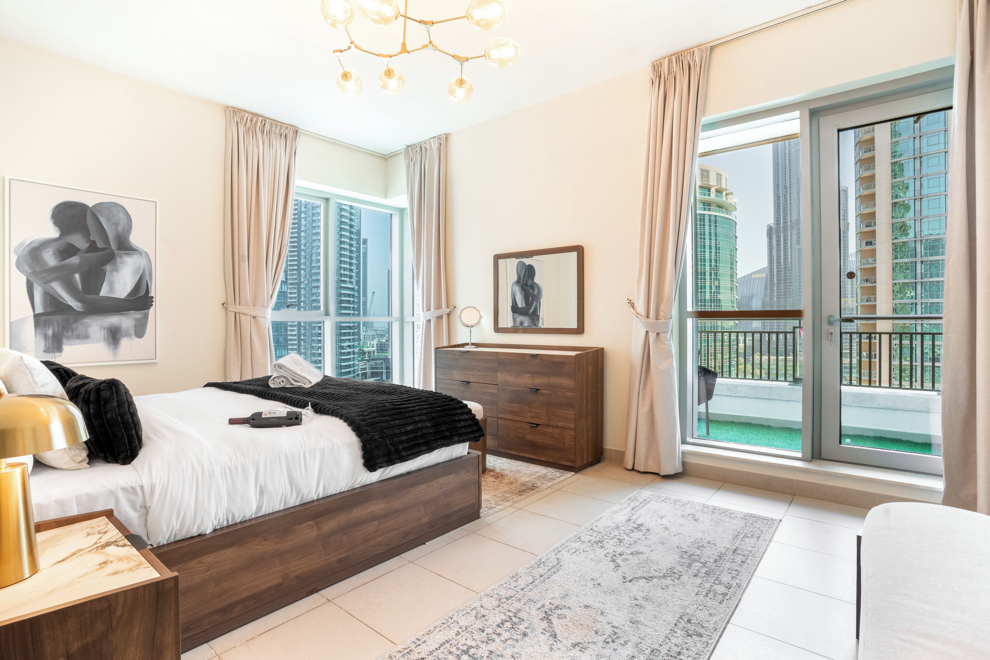 Une chambre moderne avec un grand lit, une commode, une table de chevet et une vue sur le paysage urbain par la fenêtre.