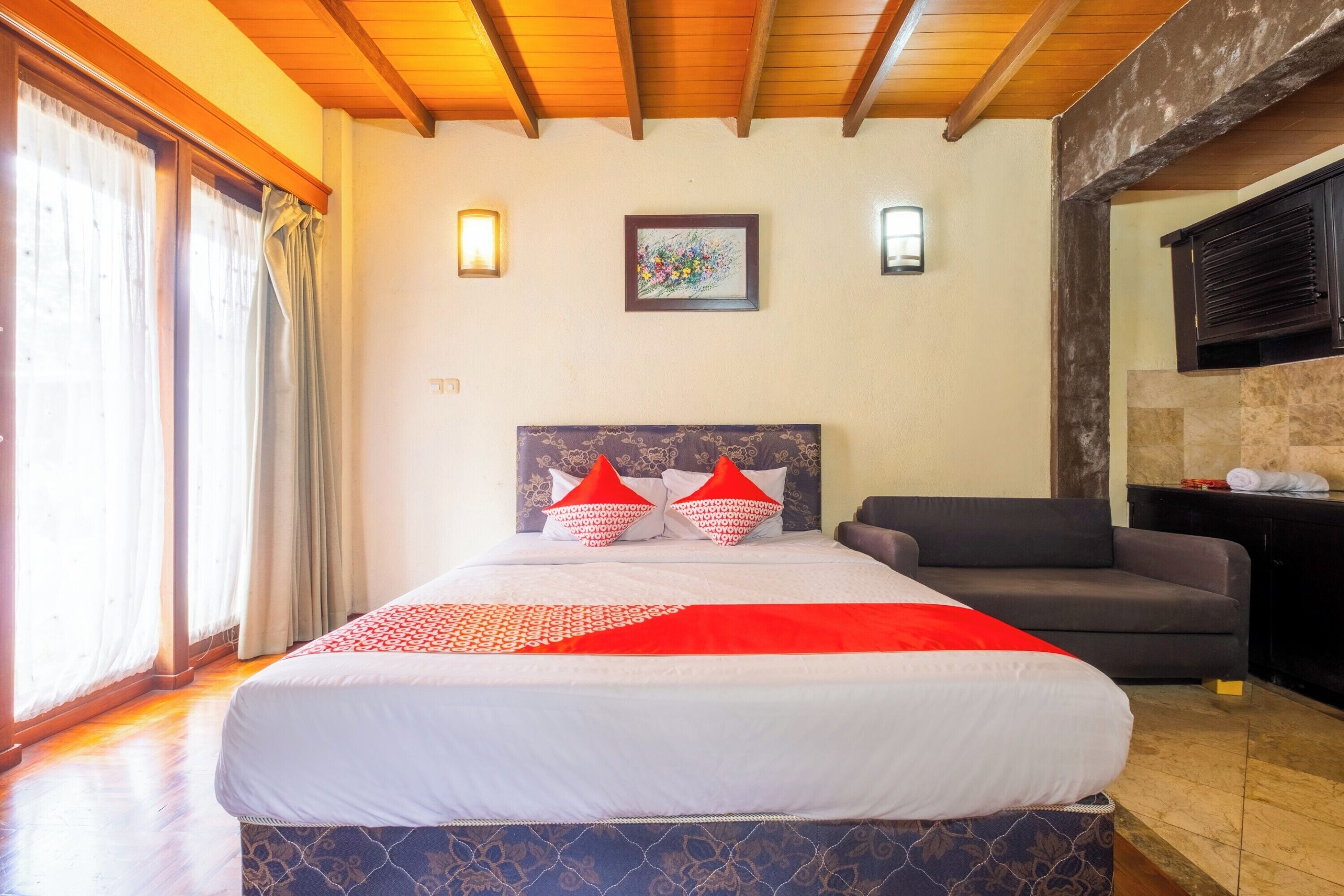 Habitación de hotel con una cama grande, un sofá, una chimenea y vistas al exterior.