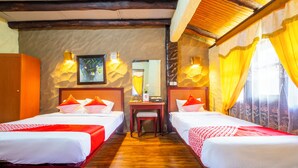 Ein Hotelzimmer mit zwei Einzelbetten, einem Holztisch und einem Spiegel.