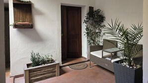 A cozy interior with a wooden bench, a door, and a hanging plant.
