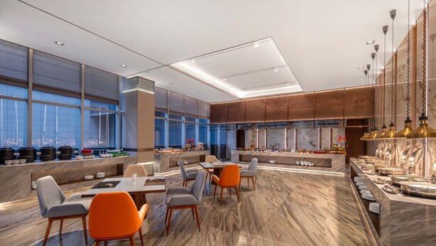 Un espace repas moderne avec un sol en marbre, des meubles contemporains et une grande fenêtre donnant sur la ville.