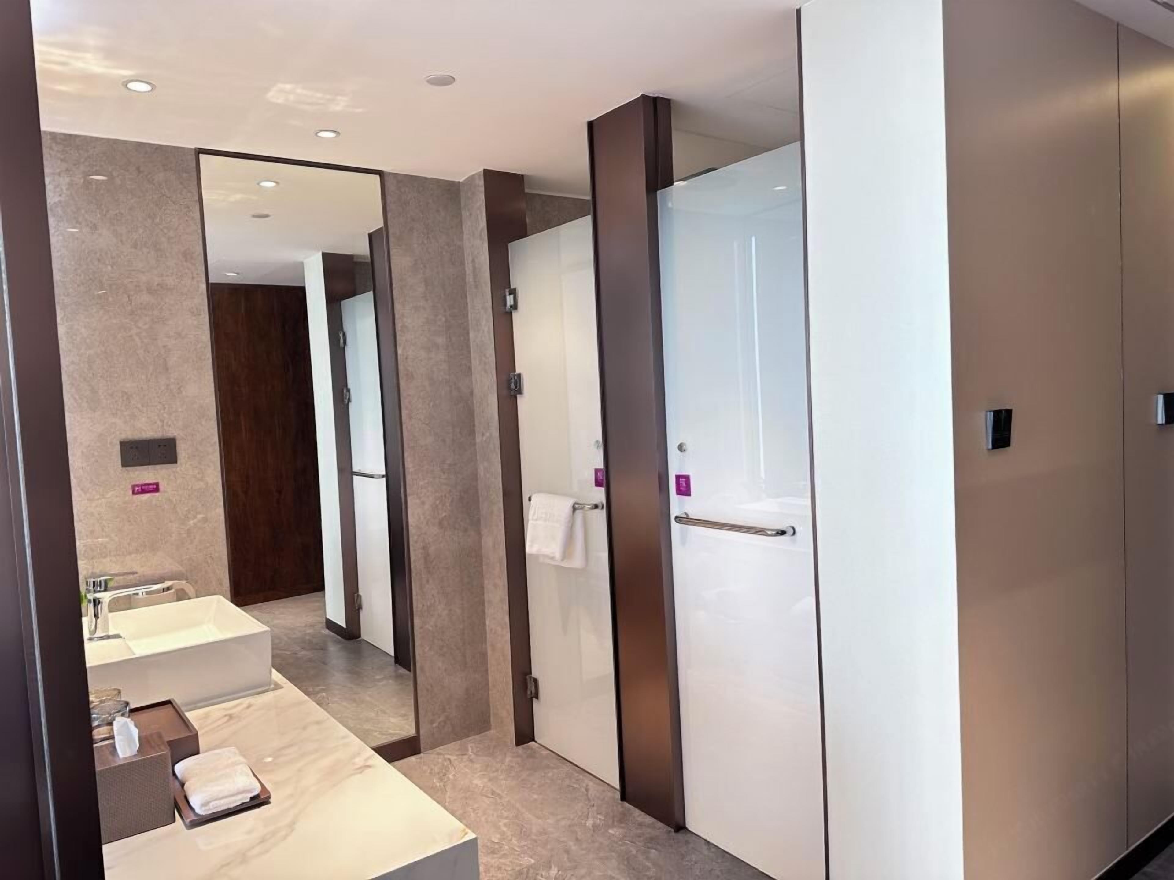 Un baño moderno con un espejo grande, un lavabo y un perchero para toallas.