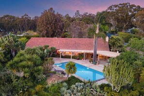 A house with a red-tiled roof, a swimming pool, and surrounding lush vegetation. - Rancho Real by AvantStay | Private Pool + Hot Tub | Luxe Group Retreat (Del Mar)