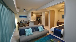 A modern living room with a sofa, a dining area, a kitchen, and a bedroom. - Branchera Naha Akebono Premist 1206 (Naha)