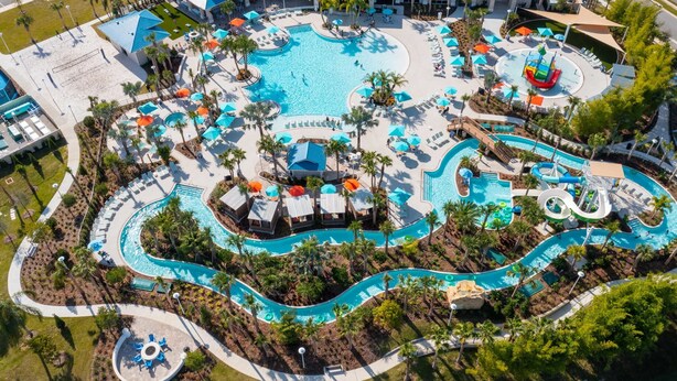 An aerial view of a resort with multiple swimming pools, palm trees, and lounge areas. - Stylish 5BR Retreat with Pool Near Disney (Davenport)