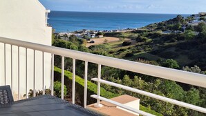 Un balcon avec vue sur la mer et sur une ville côtière.