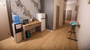 A compact kitchen with a water dispenser, microwave, and small refrigerator. - ASYL HOTEL (Astana)