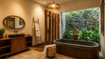 A modern bathroom with a freestanding bathtub, wooden vanity, and a large mirror.