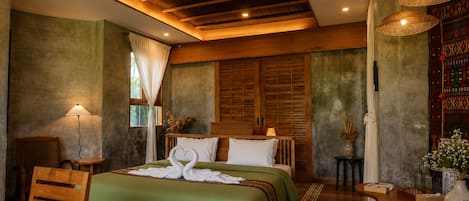 Une chambre d’hôtel avec un lit, des meubles en bois, une table et un mur décoratif.