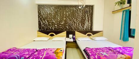 Une chambre d’hôtel avec deux lits simples, un grand miroir, un appareil de climatisation et une petite fenêtre avec un rideau.
