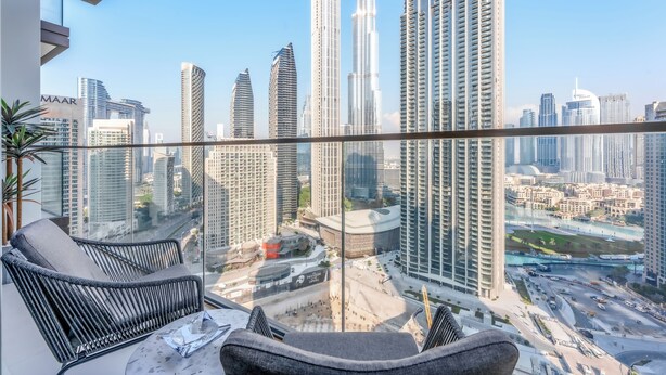 Un balcone di un grattacielo con vista sulla città, con edifici moderni e cielo sereno.