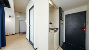 Uma cozinha moderna com máquina de lavar louça embutida e uma porta preta com puxador vermelho.