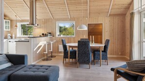 A modern interior with a dining area, kitchen, and seating space.