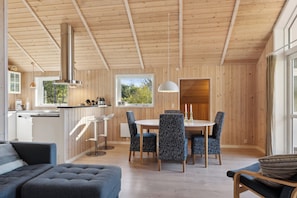 Un intérieur moderne comprenant un coin repas, une cuisine et un espace salon.