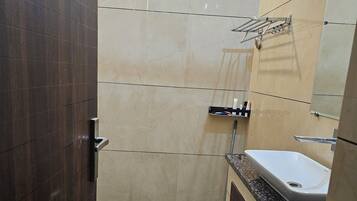 Een douche, handdoeken, zeep, shampoo