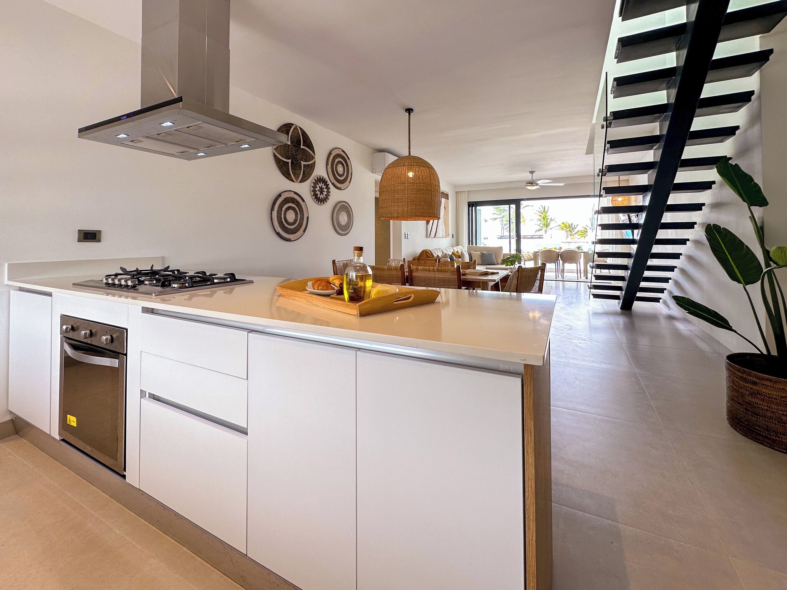 Een moderne keuken met een centraal eiland, een inbouwoven en een eetgedeelte met uitzicht.