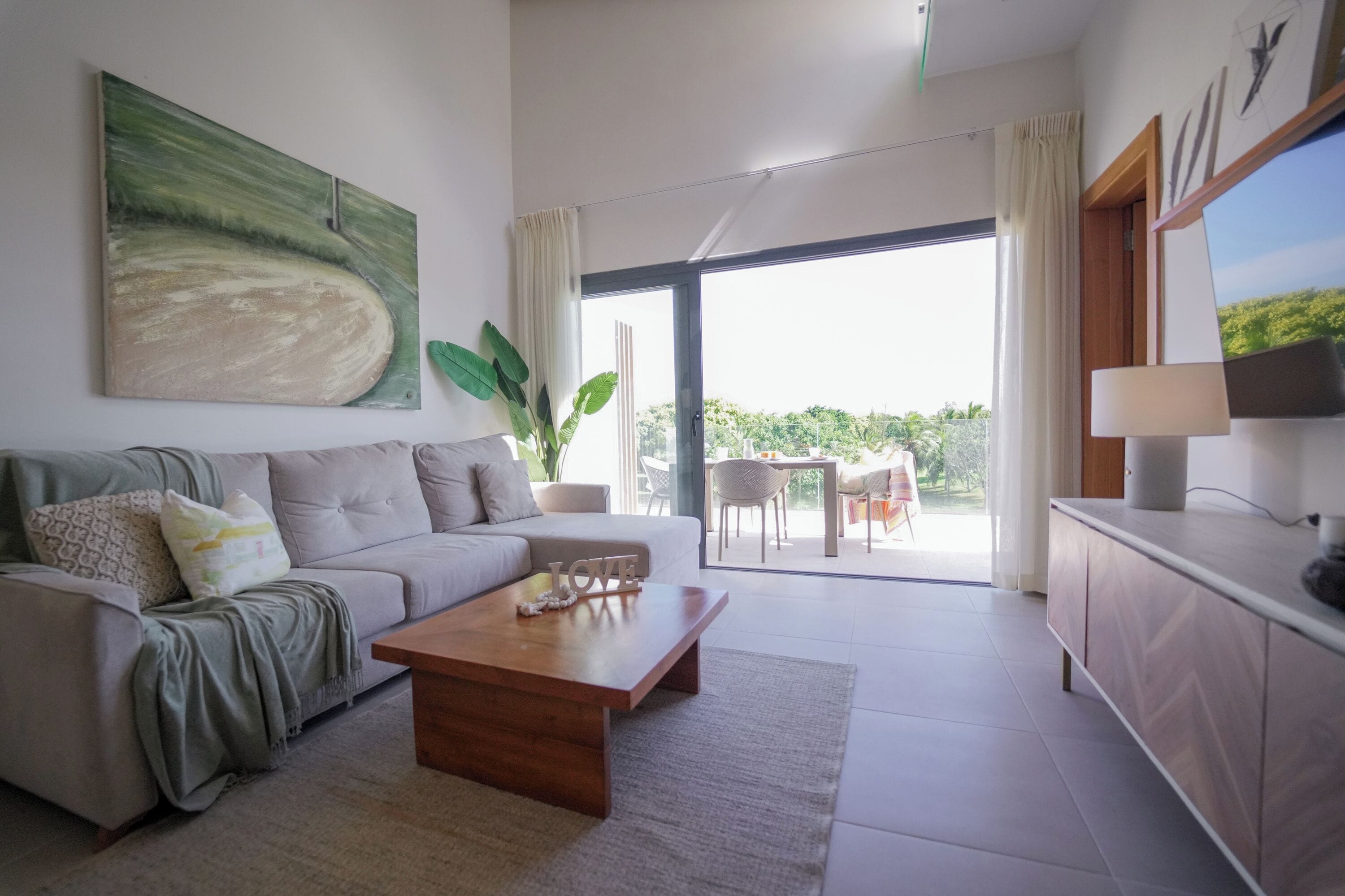Ein modernes Wohnzimmer mit Sofa, Couchtisch und einem Gemälde an der Wand.