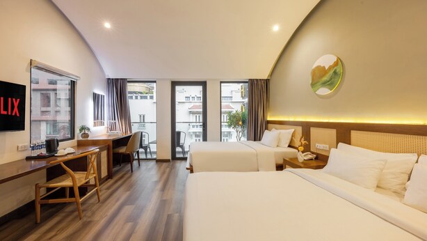 A hotel room with two beds, a desk, a chair, a TV, and a view of the city. - A25 Hotel - 14 Ho Huan Nghiep (Ho Chi Minh City)
