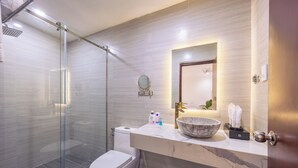 A modern bathroom with a glass shower enclosure, a marble sink, and a toilet. - A25 Hotel - 14 Ho Huan Nghiep (Ho Chi Minh City)