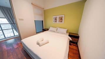 Una camera d'albergo con un letto grande, un comodino, una finestra con tende e una parete verde.